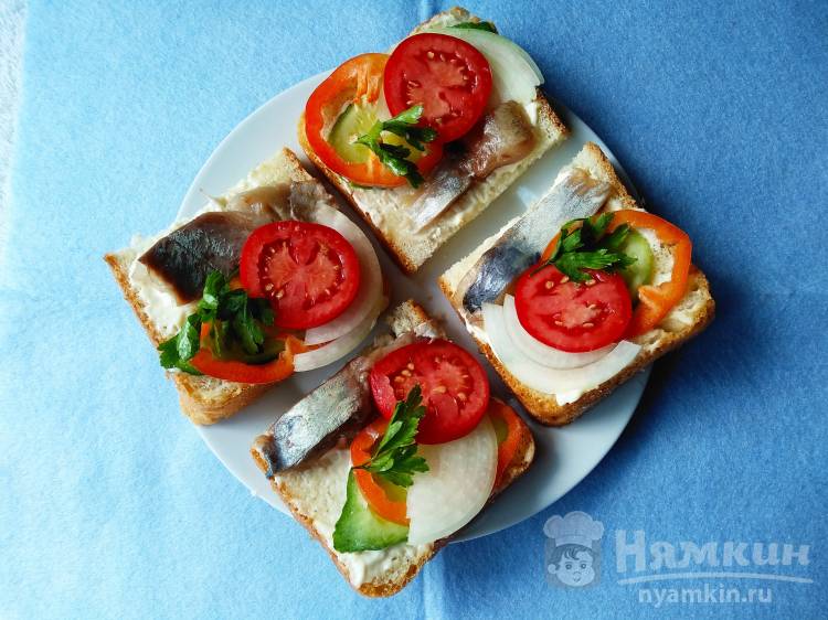 Бутерброды из белого хлеба с сельдью и свежими овощами