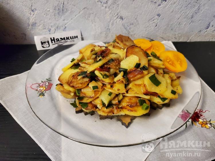 Жареная картошка с листьями чеснока и вялеными томатами на сковороде