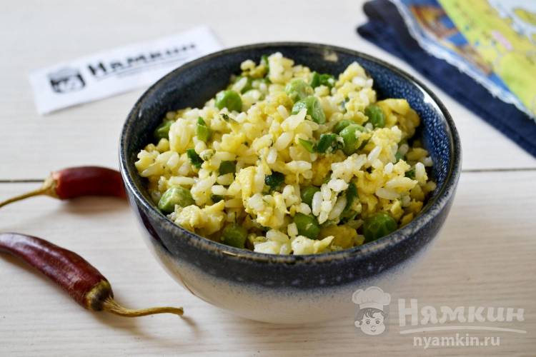 Жареный рис с яйцом и зеленым горошком на сковороде по-китайски