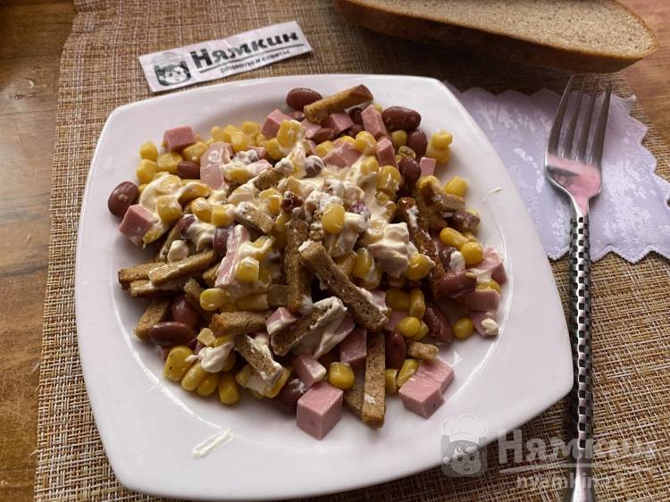 Салат с фасолью, вареной колбасой, кукурузой и сухариками