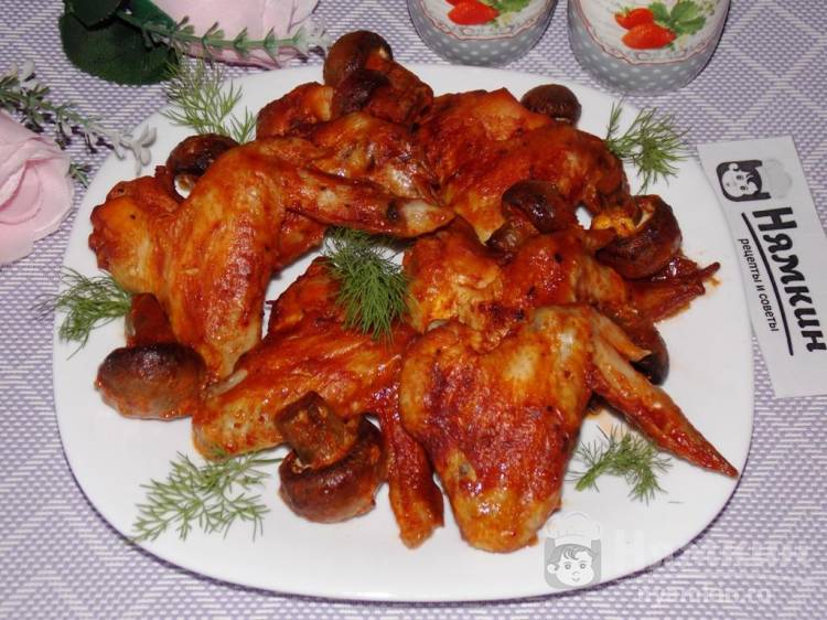 Куриные крылья с шампиньонами, запеченные в соусе из томатной пасты и майонеза